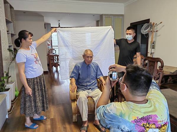 百城街道入户为行动不便的退役军人拍照办理优待证。