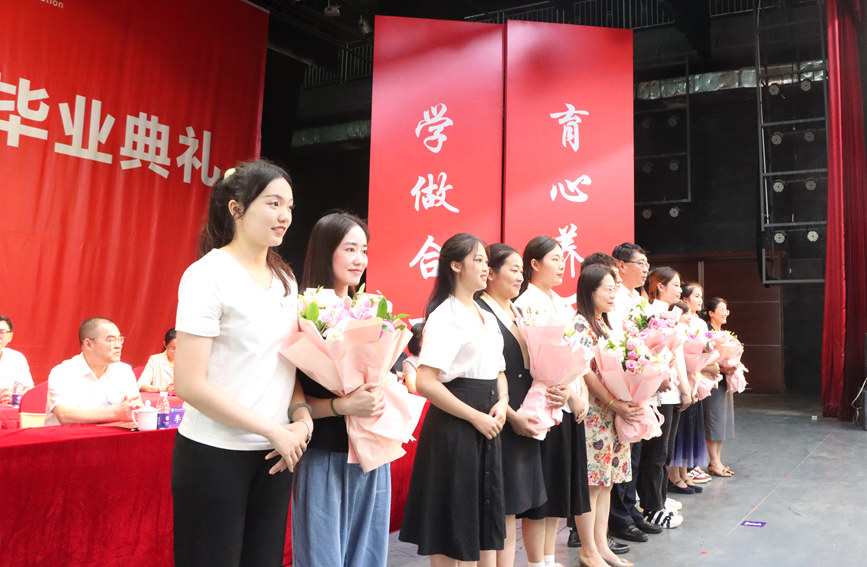 2023届毕业生代表向教师代表献花。