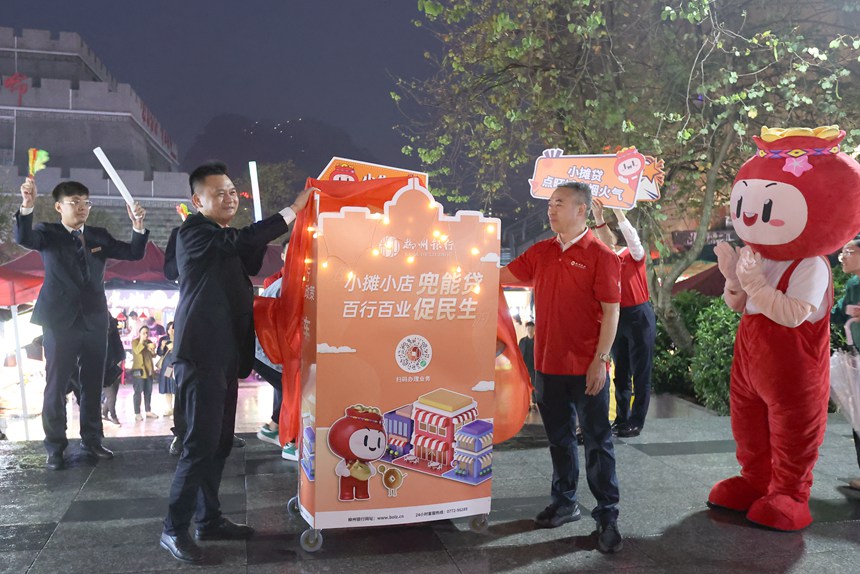 柳州银行党委副书记、行长吴建民（前左）为“小摊贷”宣传车揭牌。