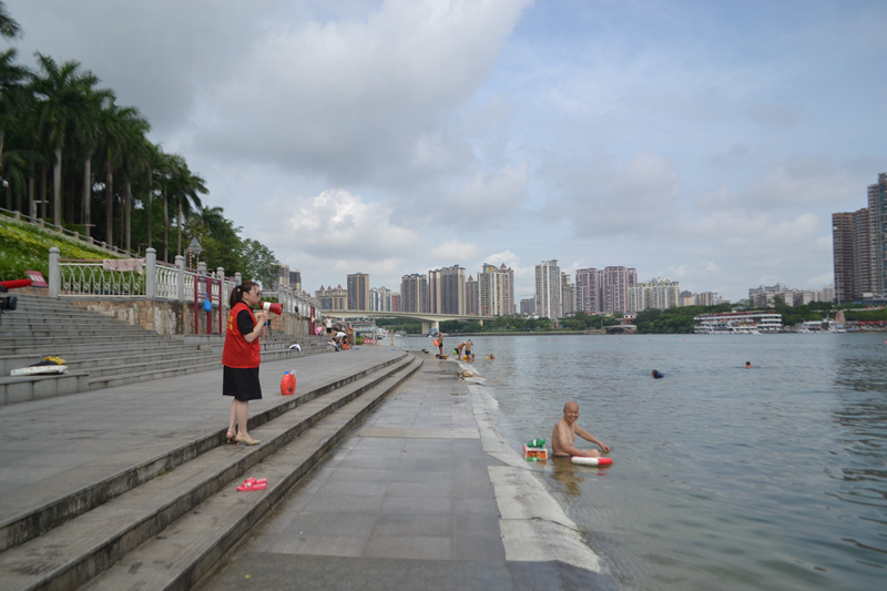 网格员正在提醒游泳居民注意安全。朱倪萱摄