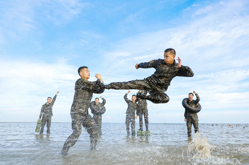 武警官兵在海水中进行实战搏击训练。