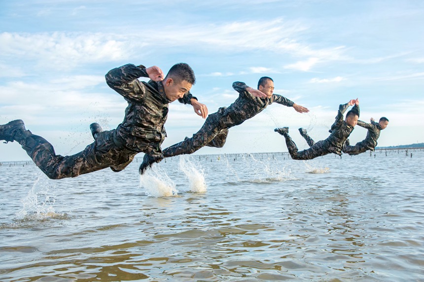 武警官兵在海水中进行倒功训练。