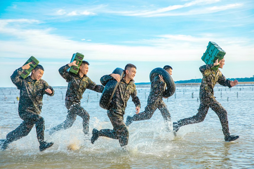 武警官兵在海水中进行负重冲刺训练。