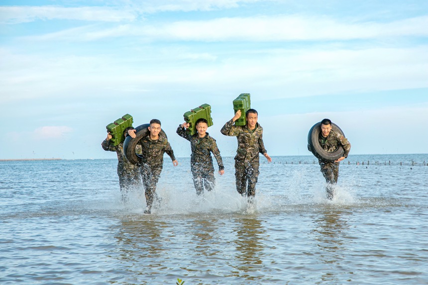 武警官兵在海水中进行负重冲刺训练。