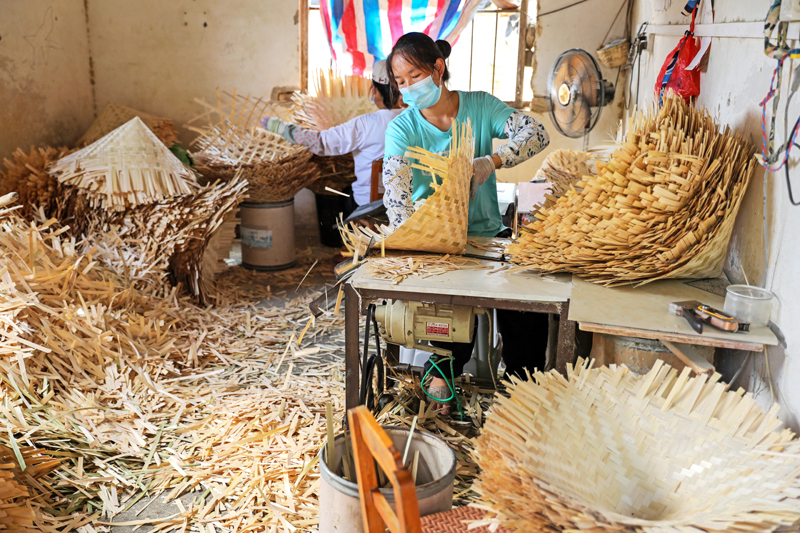 村民在為竹編帽半成品加工