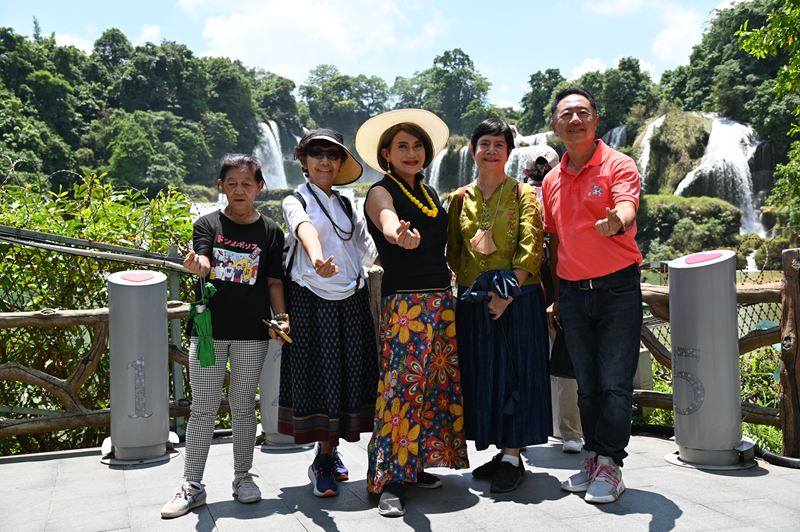 图为泰国游客在德天瀑布前拍照留念。大新县委宣传部供图