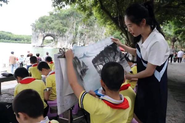 兒童在漓江邊用畫筆記錄風景