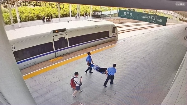 图5：车站为旅客提供担架，并协助快速送至救护车。（梁源嵩 摄）.jpg