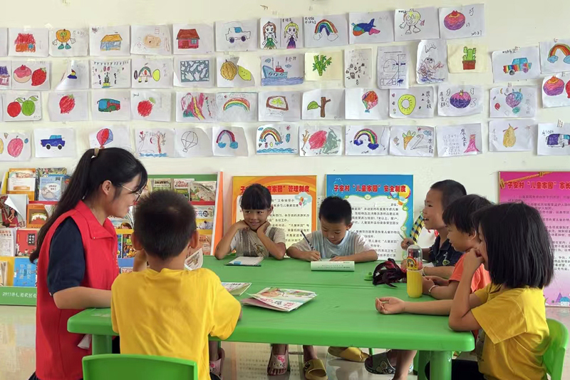 平马镇子安村的大学生在辅导孩子们绘画。田东县委宣传部供图