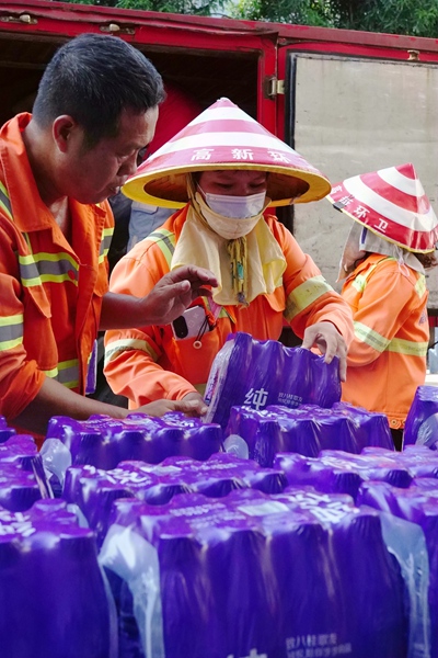 清凉饮用水送至环卫工人手中。陈亮摄