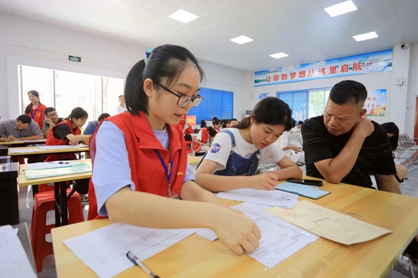 志愿者耐心指导申请办理助学贷款业务的学生。刘璇摄