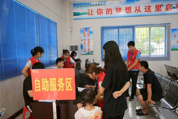 志愿者在自主服务区指导助学贷款申请业务。刘璇摄