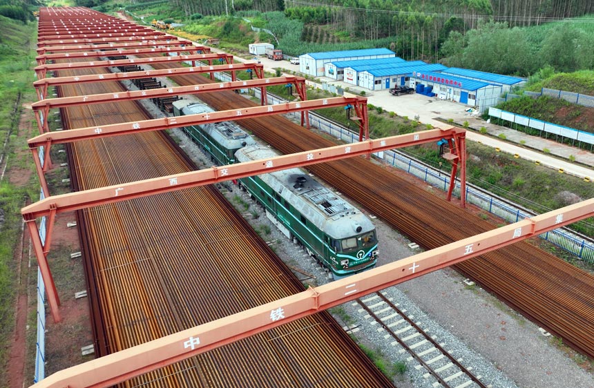 长轨运输车驶出存轨基地，将建设材料运往施工现场。黄诗伟摄