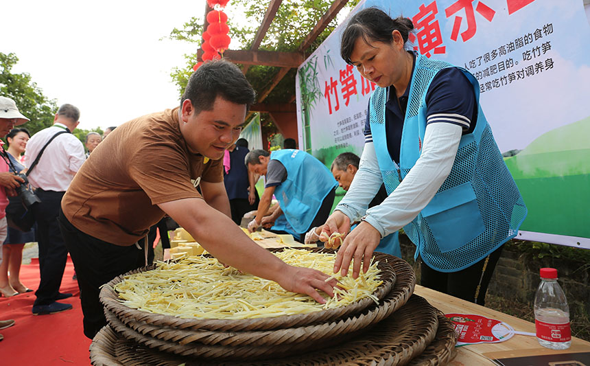 工作人员将笋条铺开准备晾晒。
