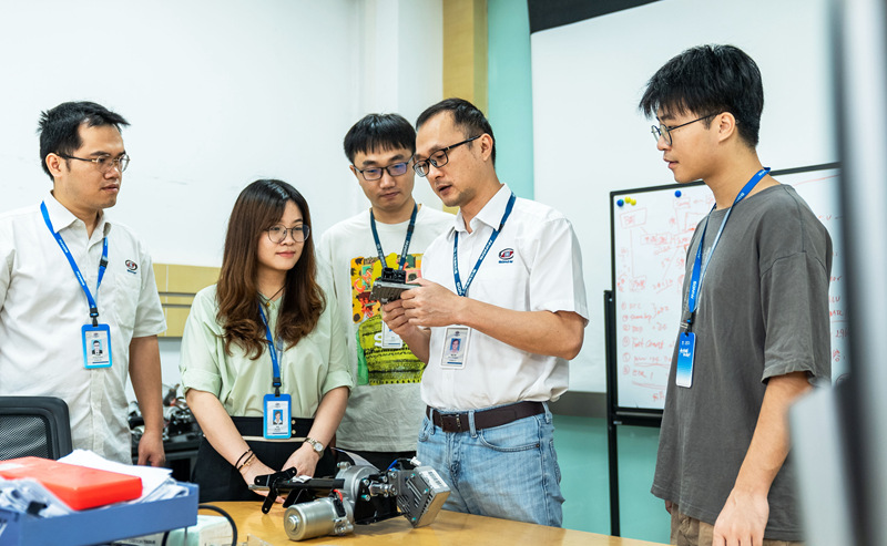 刘昌业（右二）与团队成员在讨论转向关键控制器技术方案。 上汽通用五菱供图