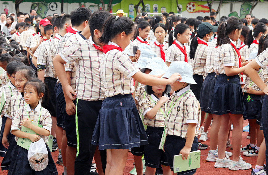 高年级同学帮新生戴帽子。梁琼之摄