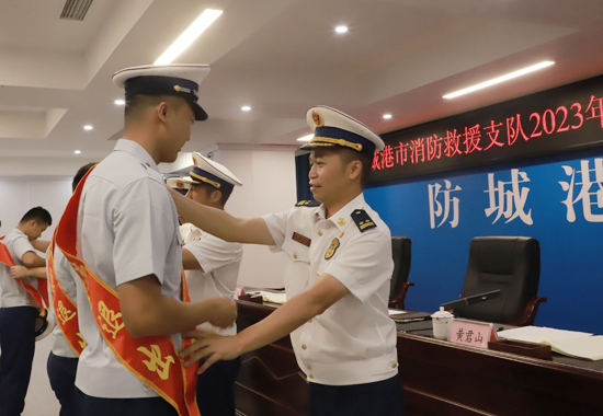 支队领导为退出消防员佩戴绶带。防城港市消防救援支队供图
