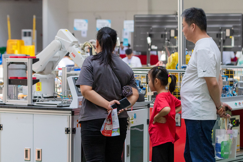 新生家长在参观智能学院的机器人。学校供图
