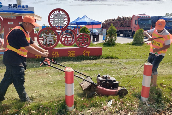 合浦公路养护中心工作人员修剪草坪。黎敏摄