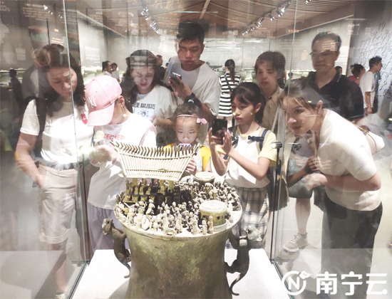 在广西民族博物馆里，古老的铜鼓吸引游客目光。梁枫摄