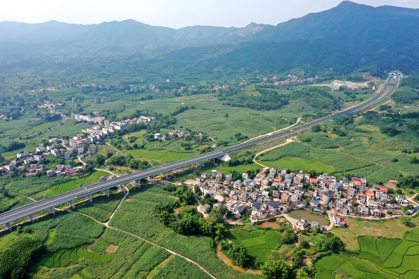10月6日，空中俯瞰下的广西宁明县峙浪乡长桥村美丽田园与穿境而过的崇爱高速公路交相辉映、美轮美奂。