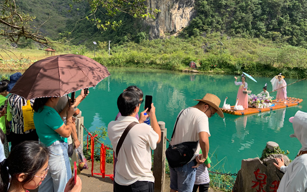 游客在鹅泉景区欣赏民俗活动。何艳玲摄