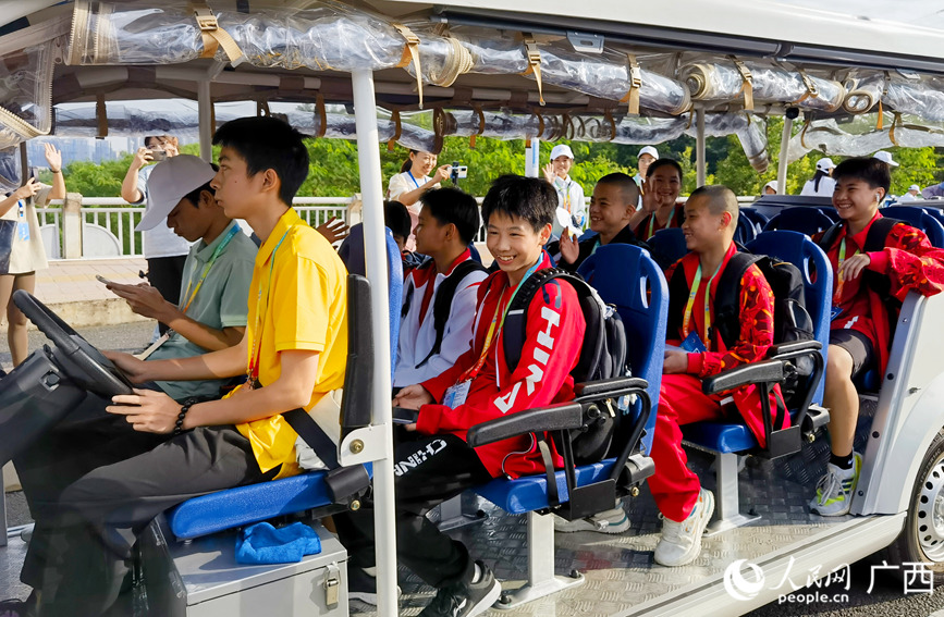 运动员乘坐电瓶车入住运动员村。人民网记者 陈燕摄