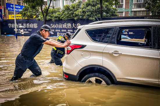 今年5月，因持续暴雨，桂林市区多个路段出现内涝，群众遇到困难，民警及时伸出援手。桂林市公安局供图