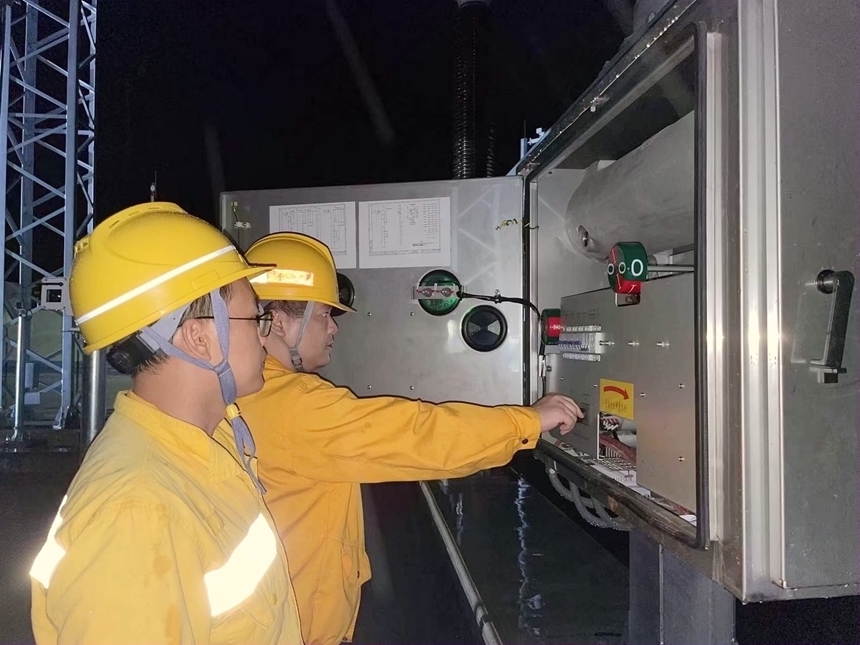 作业人员对断路器进行分合闸试验。张宇摄