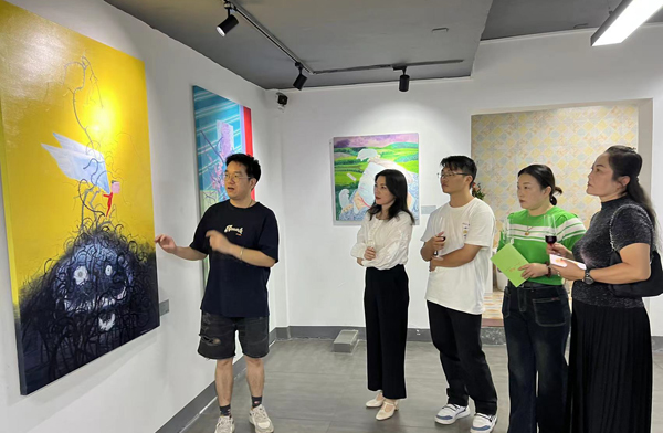 黄柱（左）与绘画爱好者们交流。主办方供图