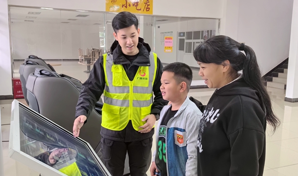 服务区管理员向游客介绍如何使用多功能查询机浏览图书