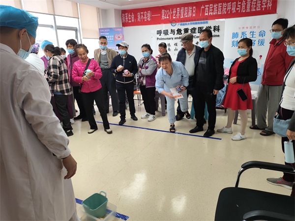 现场患者及家属在进行趣味十足的投沙包互动活动