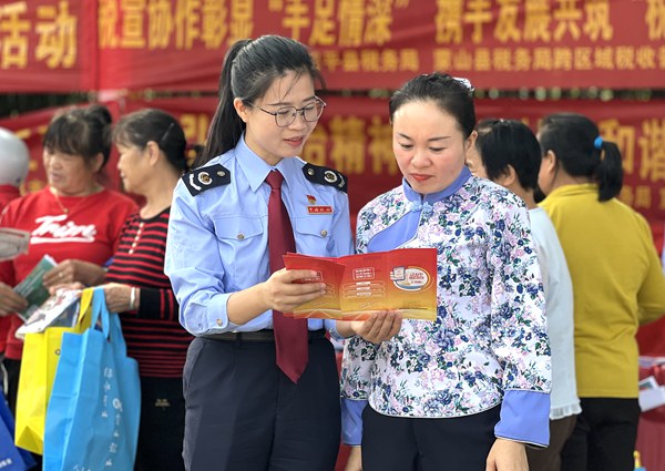 税务干部向纳税人宣传广西税务APP操作指南。黄煜格摄