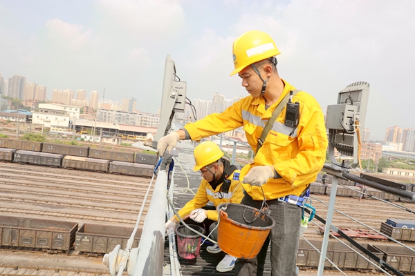 青年职工正在给灯桥栏杆刷油漆。冯卫峰摄