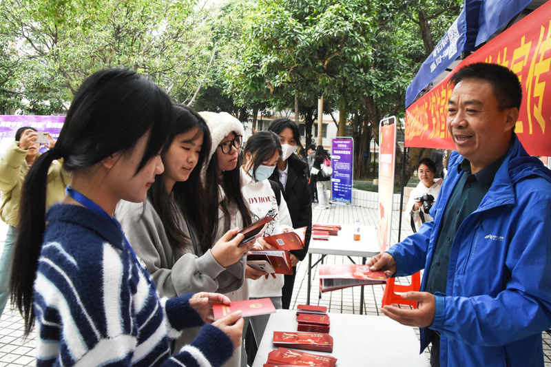 学生普法宣传活动现场与残联工作人员交谈。广西民族大学供图