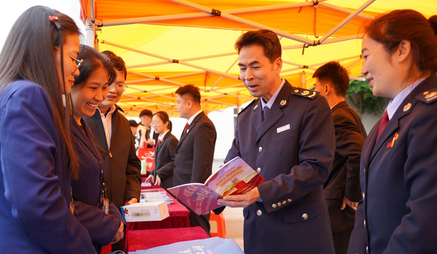 税务干部在“宪法宣传周”暨“宪法进园区（企业）”主题宣传活动中向企业职工宣传宪法等法律知识 (梧州市税务局 供图）
