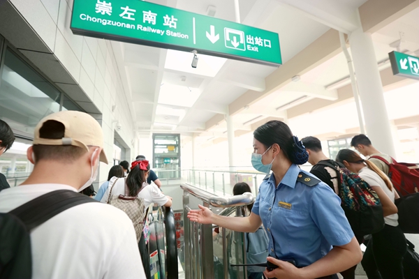 崇左南站工作人员引导旅客出站。李伊摄