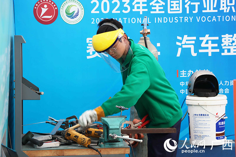 汽车整车装调工项目比赛现场，参赛选手正在动手制作参赛新能源车零部件。人民网 付华周摄