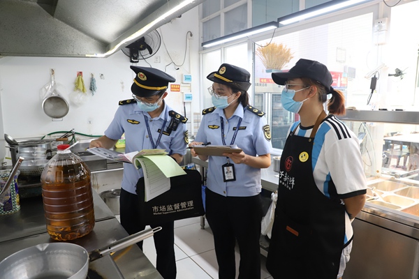 北海市市场监管局执法人员在食品经营店开展食品安全检查。谢金玲摄