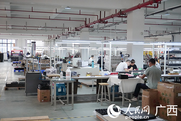 在广西蕴奥智能包装有限公司的生产车间，工人正加紧作业。人民网记者 黄子婧摄