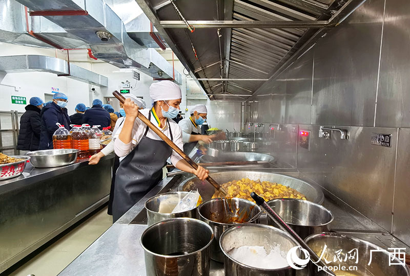 隆安县粤桂小学，食堂工作人员正在为学生准备午餐。人民网 付华周摄