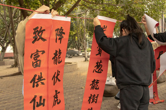 同学们在挑选春联。陆丽洁摄