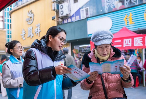 志愿者向群众发放宣传册