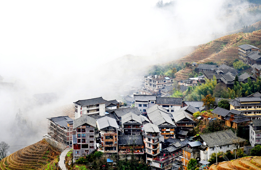 層層疊疊的梯田和錯落有致的吊腳樓在雲海間若隱若現