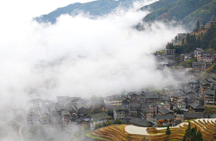 層層疊疊的梯田和錯落有致的吊腳樓在雲海間若隱若現