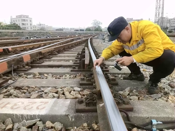 玉林工务段职工在寒冷天气中检查道岔钢轨运行情况。陈鑫摄