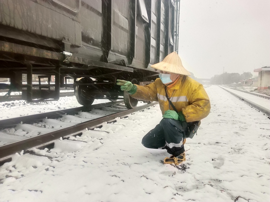 为保障列车安全整点运行，桂林车务段三街站调车人员在风雪中检查车辆状况。陈元昌摄