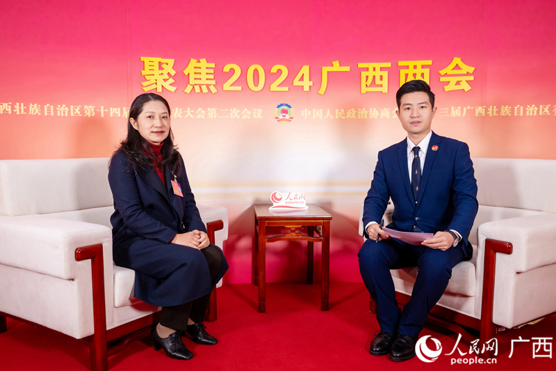 覃鸿代表（左）接受专访。人民网记者 严立政摄