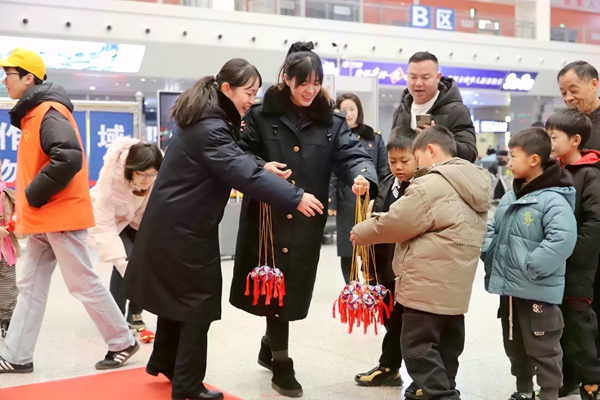 工作人员给旅客分发绣球投福袋,让旅客带上新春祝福踏上旅途。陈泽昊摄