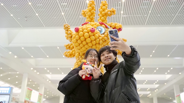 旅客在龙年造型前自拍。李俊鸣摄
